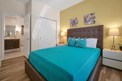 a bedroom with a large bed with a blue blanket at 1617 Retreat Circle Clermont 3 BED in Orlando