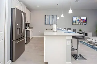a kitchen with a refrigerator and a white counter top at Casa 4 Quartos c/ Piscina Privativa - Disney in Kissimmee