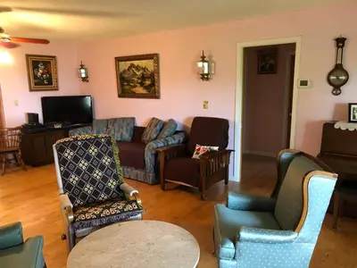 a living room with a couch and chairs at Family retreat with lake views and near Disney in Saint Cloud