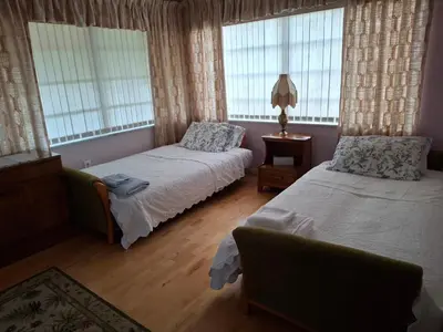 a bedroom with two beds and two windows at Family retreat with lake views and near Disney in Saint Cloud