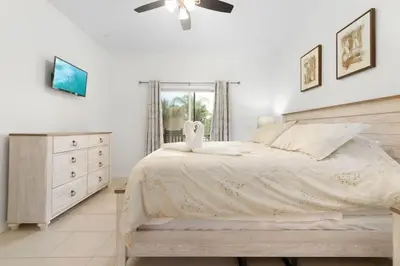 a bedroom with a bed and a dresser with a swan on it at 2888 OAKWATER KISSIMMEE 3BEDS in Orlando