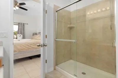 a glass shower in a bedroom with a bed at 2888 OAKWATER KISSIMMEE 3BEDS in Orlando
