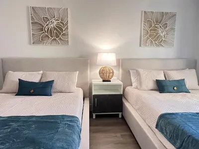 two beds with blue pillows in a bedroom at Suite near Epic Universe & Universal, free parking in Orlando