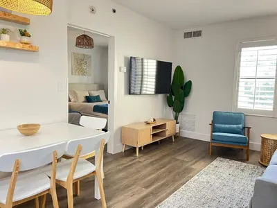 a living room with a table and a bedroom at Suite near Epic Universe & Universal, free parking in Orlando