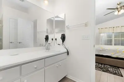 a white bathroom with a sink and a mirror at 7742 WATER OAK KISSIMMIEE 4BED in Orlando