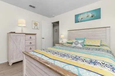 a bedroom with a large bed and a dresser at 7742 WATER OAK KISSIMMIEE 4BED in Orlando