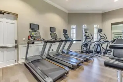 a gym with several treadmills in a room at Amplo apê 4 quartos no Vista Cay Resort in Orlando