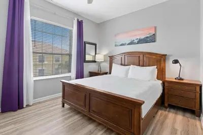 a bedroom with a bed and a window with purple curtains at Amplo apê 4 quartos no Vista Cay Resort in Orlando