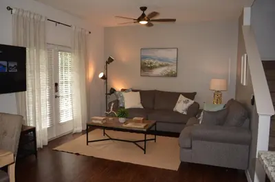 a living room with a couch and a table at Charming 4-Bedroom Townhome in Lucaya Village Near Disney in Kissimmee