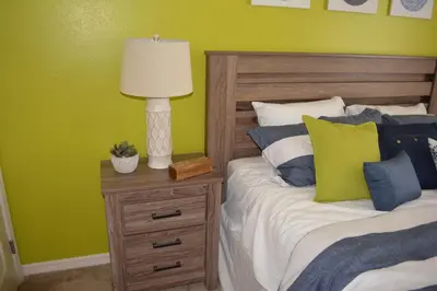a bedroom with two beds and a lamp on a night stand at Charming 4-Bedroom Townhome in Lucaya Village Near Disney in Kissimmee