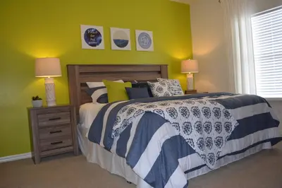 a bedroom with a bed and two lamps and a window at Charming 4-Bedroom Townhome in Lucaya Village Near Disney in Kissimmee
