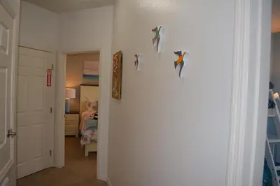 a room with a hallway with a wall with birds on it at Charming 4-Bedroom Townhome in Lucaya Village Near Disney in Kissimmee