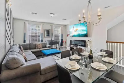 a living room with a couch and a table at Moderno Triplex 3 Quartos no Vista Cay in Orlando