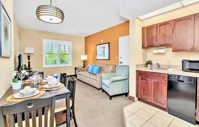 a kitchen and living room with a table and a couch at Peaceful 1 King BR Apartment w Hot Tub & Pool in Orlando