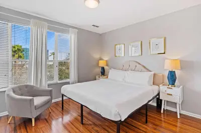 a bedroom with a bed and a chair and windows at Apartamento 3 Quartos no Vista Cay perto da Disney in Orlando