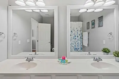 a bathroom with two sinks and two mirrors at Apartamento 3 Quartos no Vista Cay perto da Disney in Orlando