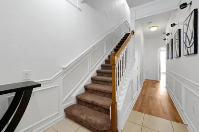 a staircase in a home with white walls and wood floors at Beautiful Epic Universe Townhome, Vista Cay-4034 in Orlando
