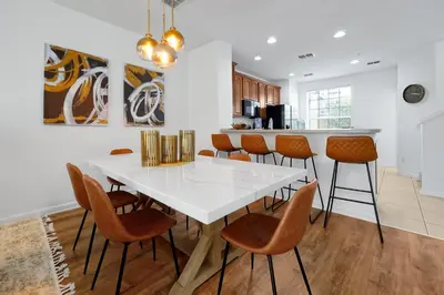 a kitchen with a white table and chairs at Beautiful Epic Universe Townhome, Vista Cay-4034 in Orlando