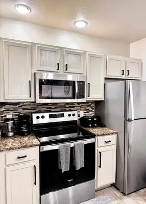 a kitchen with a stove and a stainless steel refrigerator at Modern 3BR Retreat with Comfort & Style Near Disney in Kissimmee