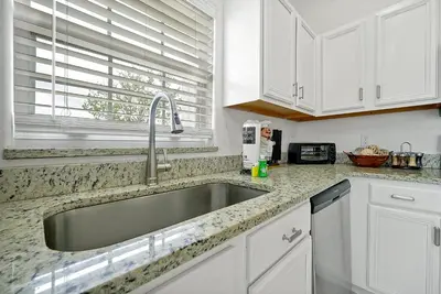 a kitchen with a stainless steel sink and white cabinets at 108 Stetson Court Kissimie in Kissimmee