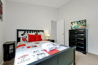 a bedroom with a large bed with red pillows at 108 Stetson Court Kissimie in Kissimmee