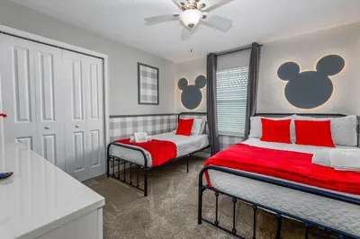 a bedroom with two beds with red pillows and a window at TVPM-5005WASL in Kissimmee