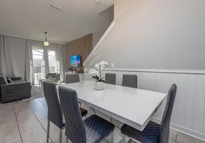 a dining room with a white table and chairs at TVPM-5005WASL in Kissimmee