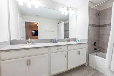 a bathroom with two sinks and a large mirror at TVPM-5005WASL in Kissimmee