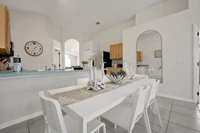 a white kitchen with a white table and white chairs at 938 Lake Berkley Kissimmee FL 34746 in Kissimmee