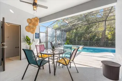a dining room with a table and chairs and a pool at TVPM-1191MBBV in Kissimmee