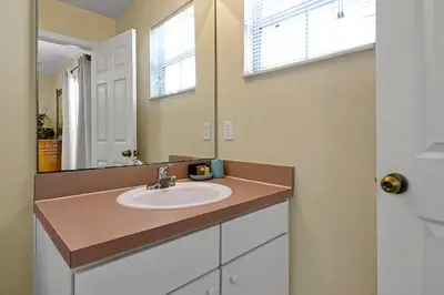 a bathroom with a sink and a mirror at 4703 Flagler Beach Way Kissimmee Florida 3BED in Kissimmee