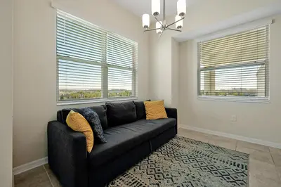 a black couch in a living room with two windows at 3161 PARADOX CIRCLE UNIT 406 KISSIMMEE 2 BEDS in Kissimmee