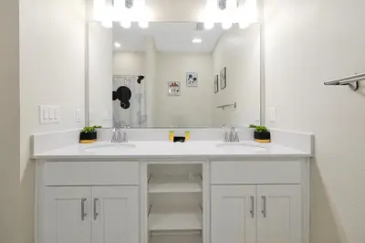 a bathroom with two sinks and a large mirror at 3161 PARADOX CIRCLE UNIT 406 KISSIMMEE 2 BEDS in Kissimmee