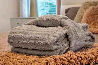 a pile of blankets sitting on top of a bed at 5017 WINDERMERE 4BED in Kissimmee