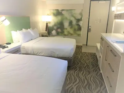 a hotel room with two beds and a bathroom at Wyndham Garden Lake Buena Vista – Disney Springs® Area in Orlando