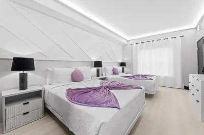 two beds in a white bedroom with purple sheets at Prime Location 1BR Apt Near Epic OCCC in Orlando