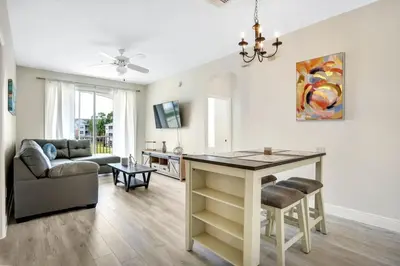 a kitchen and living room with a table and a couch at Big Condo 3 bedrooms, Pool in Kissimmee
