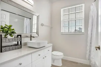 a white bathroom with a sink and a mirror at Big Condo 3 bedrooms, Pool in Kissimmee