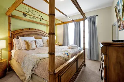 a bedroom with a large bed with a wooden frame at 7823 BEACHFIELD KISSIMME 4BED in Orlando