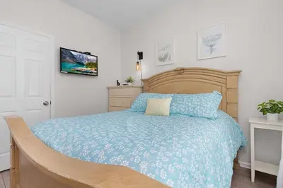 a bedroom with a wooden bed with a blue blanket at 2554 RENSHAW ST KISSIMMEE 3BEDS in Orlando