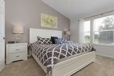 a bedroom with a large bed and a window at 2554 RENSHAW ST KISSIMMEE 3BEDS in Orlando