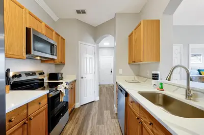 a kitchen with wooden cabinets and a sink at 8105 COCONUT PALM WAY UNIT 205 KISSIMMEE 3BEDS in Kissimmee