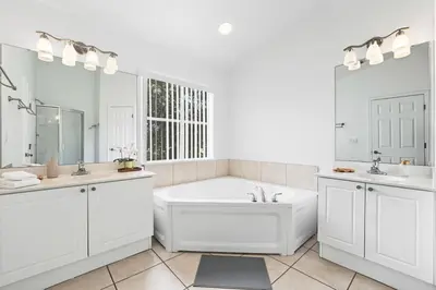a white bathroom with a tub and two sinks at Pond View Club Cortile Resort Pool Hot Tub Theme in Kissimmee