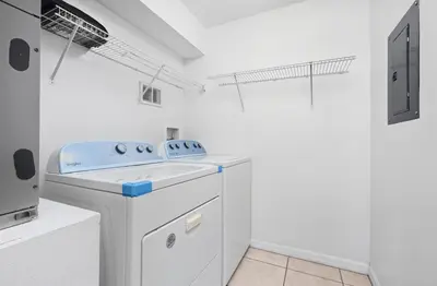 a white laundry room with a washer and dryer at Pond View Club Cortile Resort Pool Hot Tub Theme in Kissimmee