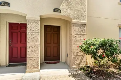 two red doors on the side of a building at Pond View Club Cortile Resort Pool Hot Tub Theme in Kissimmee