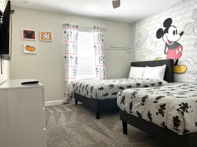 a bedroom with two beds and a mickey mouse mural at Stunning Retreat Townhouse 4 Beds and 10 Mins to Disney With Pool in Kissimmee