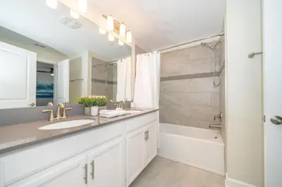 a white bathroom with a sink and a shower at Stunning Retreat Townhouse 4 Beds and 10 Mins to Disney With Pool in Kissimmee
