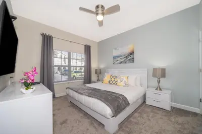 a white bedroom with a bed and a ceiling fan at Stunning Retreat Townhouse 4 Beds and 10 Mins to Disney With Pool in Kissimmee