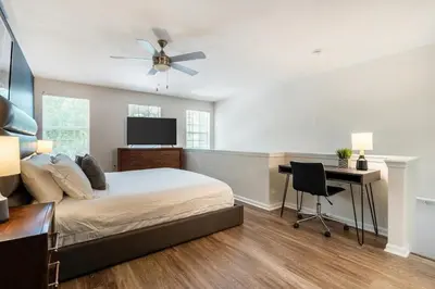 a bedroom with a bed with a desk and a ceiling fan at Landing Beautiful 1BD Gym Pool in Orlando