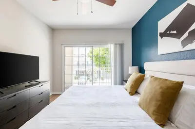 a bedroom with a large bed with a flat screen tv at Landing Beautiful 1BD Gym Pool in Orlando